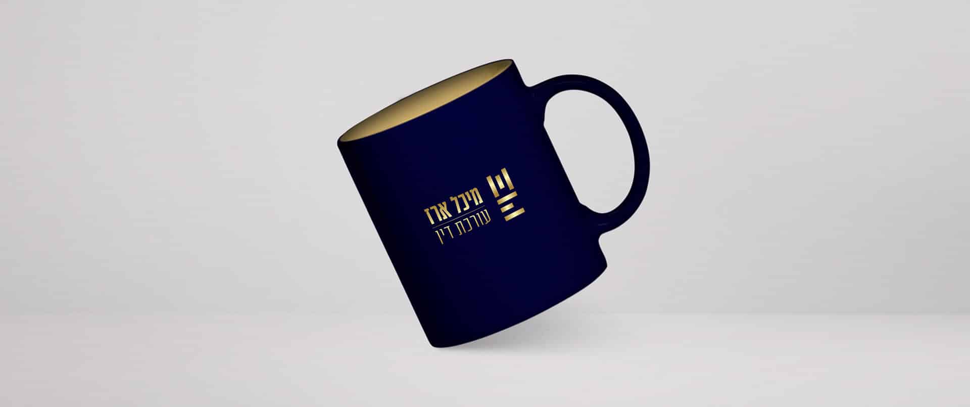 מוקאפ ספל כחול כהה עם הלוגו של עורכת הדין מיכל ארז